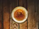 A glass of beer seen from above on an old wooden table
