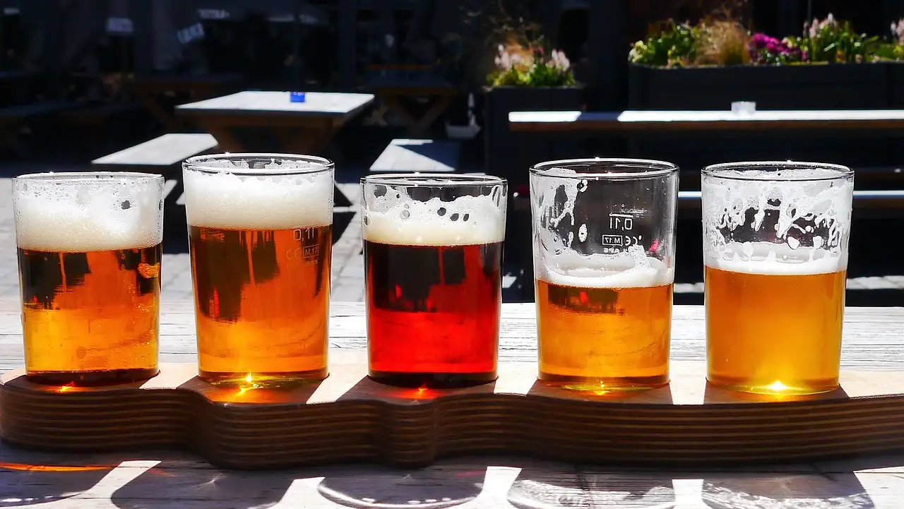 A paddle of five beers in different colours on a wooden board