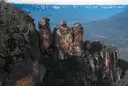 Sandstone cliffs and a wide forested valley seen from a lookout