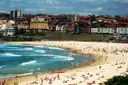 Bondi Beach with swimmers and the town behind the sand