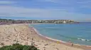 The long curve of Bondi Beach seen from the headland, with the sea on the right