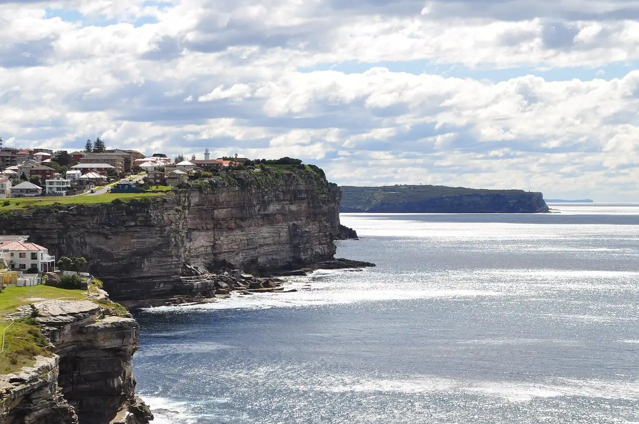 Sandstone cliffs above the sea near Bondi, with houses on the headland