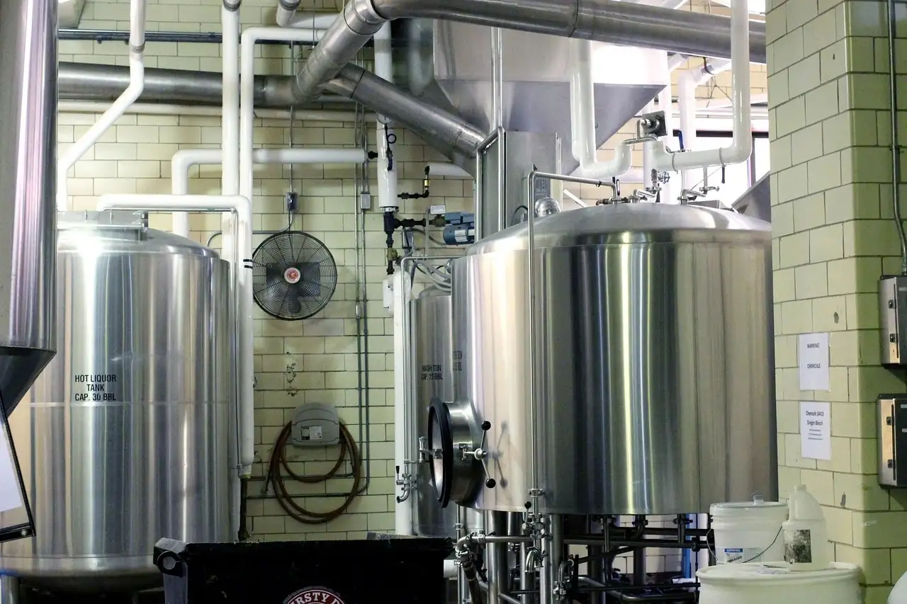 Steel brewing tanks and pipes inside a brewery