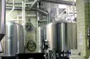Steel brewing tanks and pipes inside a brewery