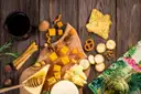A board of cut cheeses, crackers and honey on a wooden table