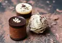Three chocolate truffles on a dusty brown surface