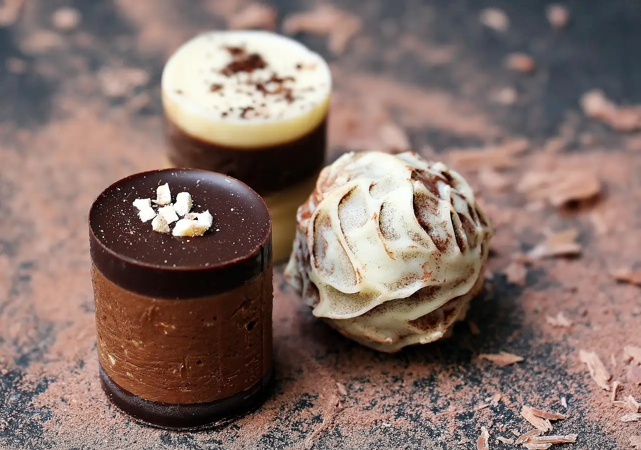 Three chocolate truffles on a dusty brown surface
