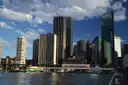 Ferries docked at the Circular Quay wharves in front of Sydney's city towers on a sunny day