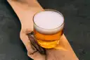 A glass of golden craft beer on a wooden board