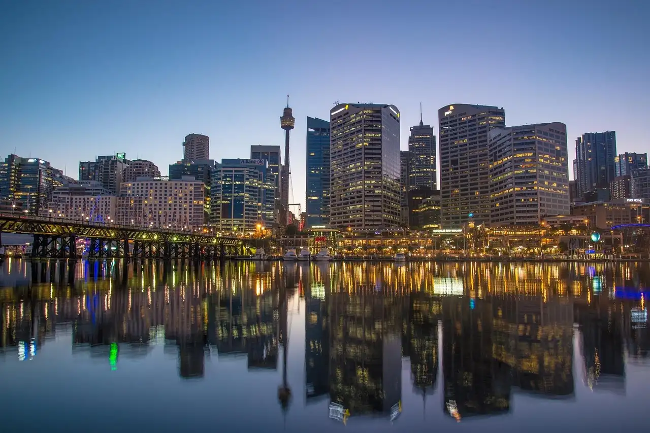 Darling Harbour at blue hour, city towers and Sydney Tower reflected in the calm water of Cockle Bay
