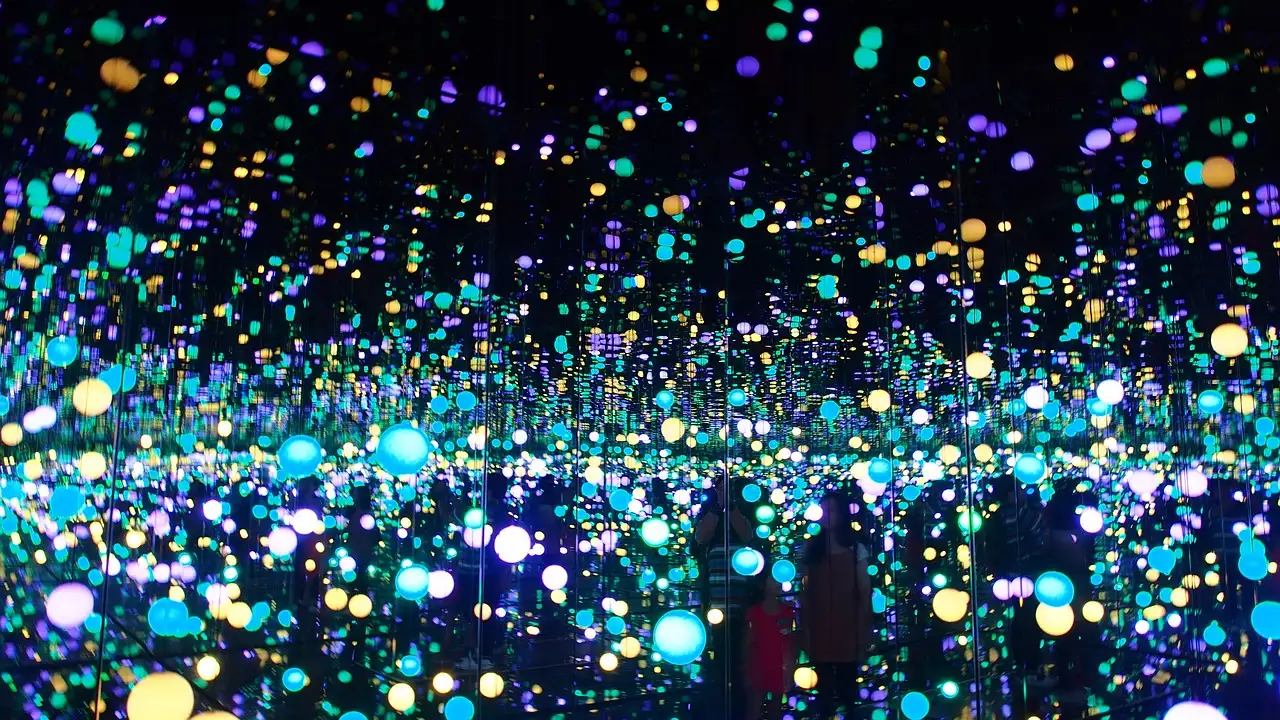 Dark mirrored room filled with endless points of coloured light