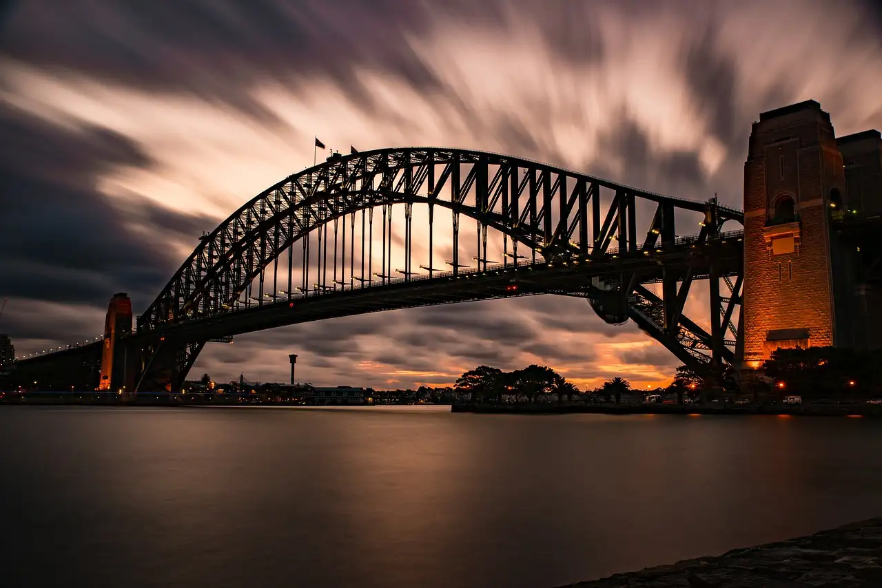 The Sydney Harbour Bridge at dusk under a streaked evening sky