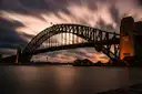The Sydney Harbour Bridge at dusk under a streaked evening sky