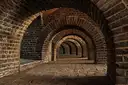 Old brick vaulted cellar with a row of arches in dim warm light