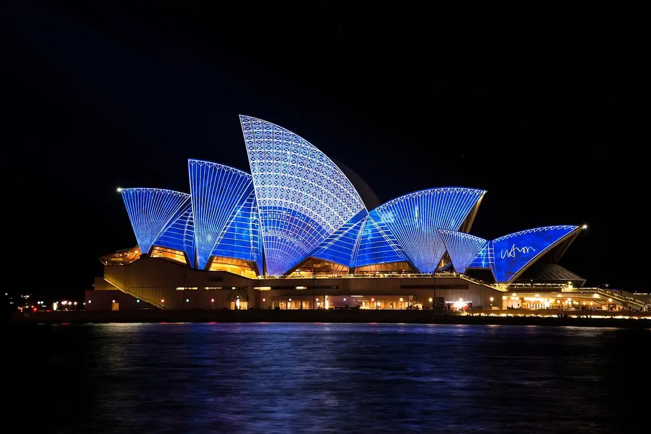 The sails of the Sydney Opera House lit in blue patterns at night