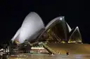 Sydney Opera House lit up at night above its wide forecourt steps