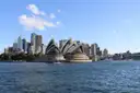 The Sydney Opera House and the city skyline seen from the harbour on a sunny day