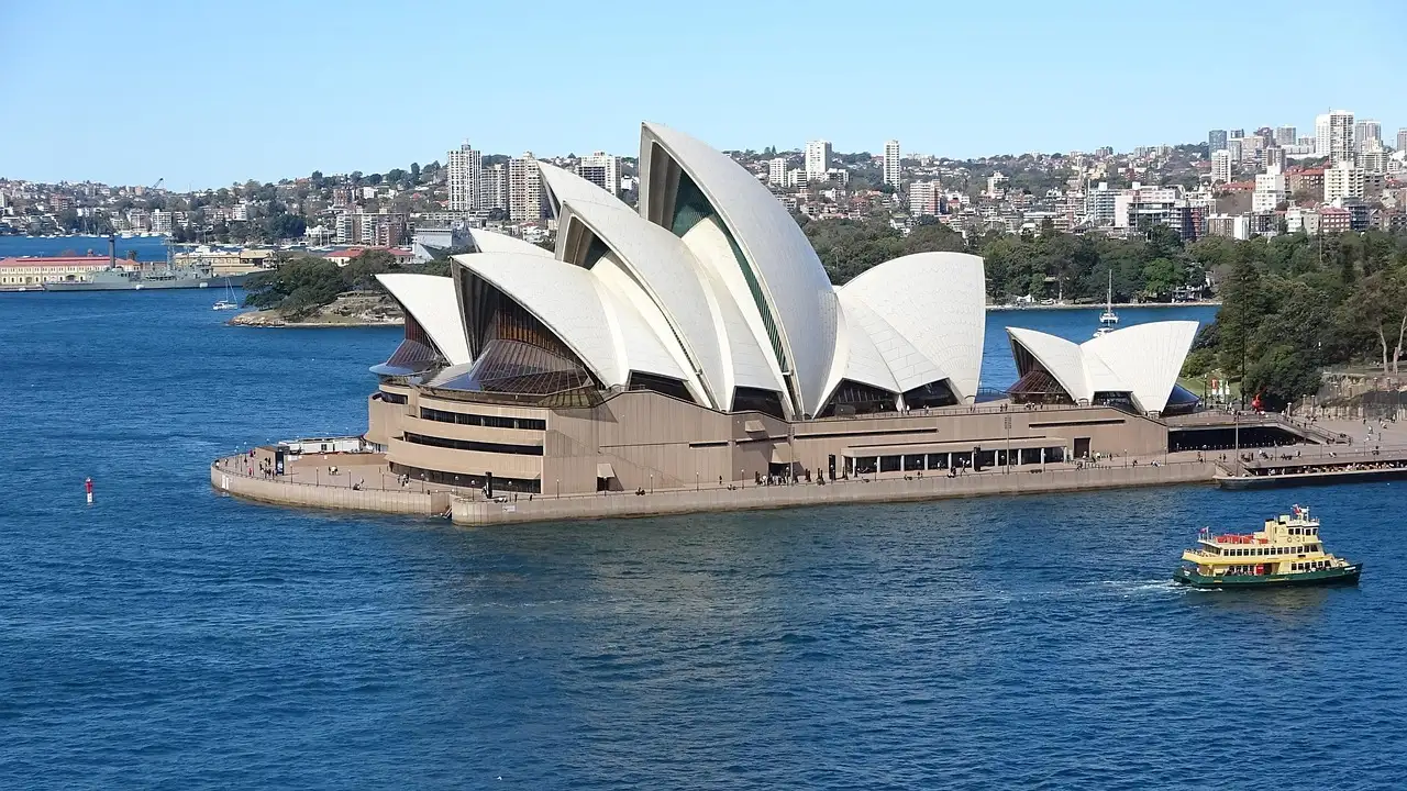 The Sydney Opera House on the harbour, with a small ferry on the water