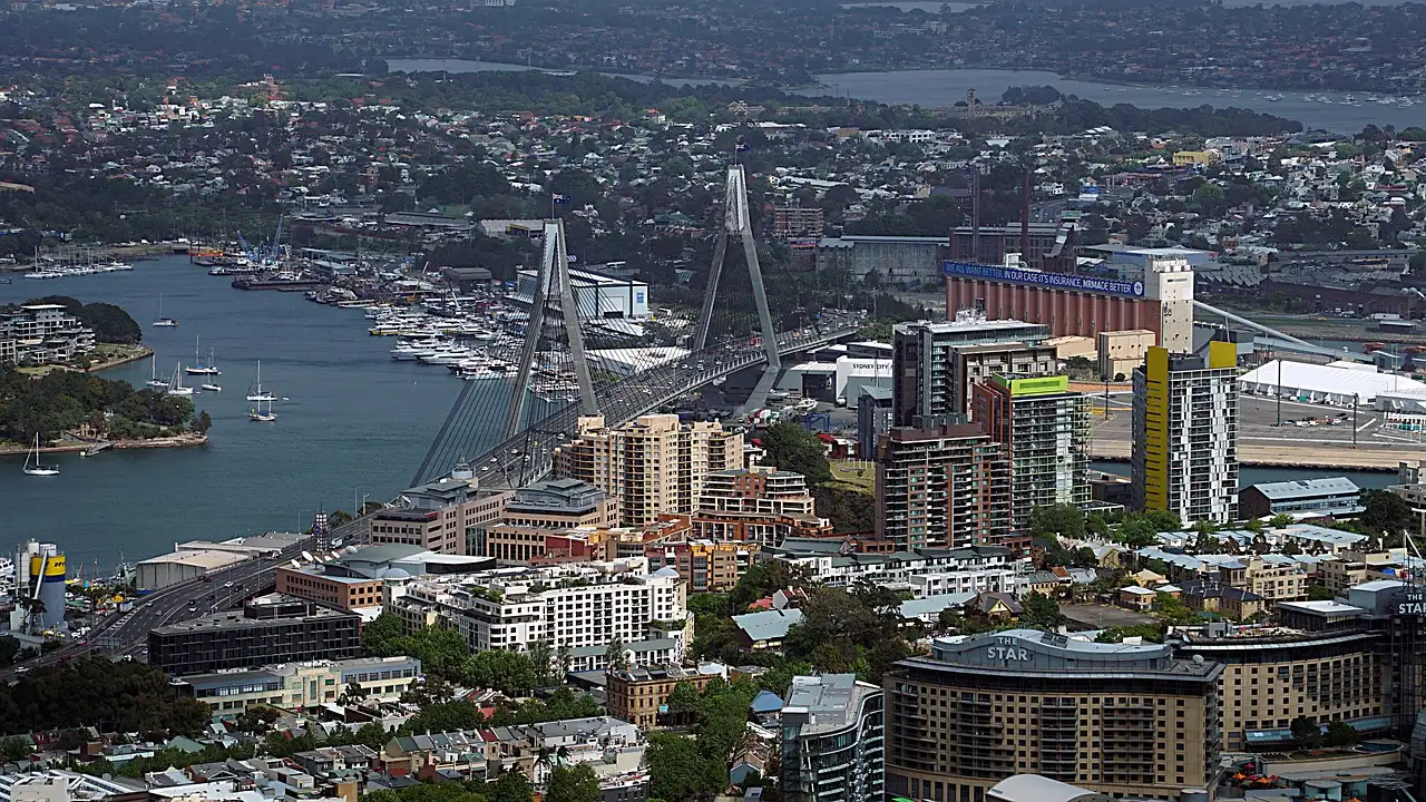 A view from above over Sydney's inner west, with a cable bridge across the water