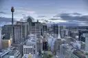Sydney city centre from above, office towers and older buildings with Sydney Tower rising over the CBD