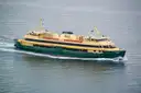 Green and cream Manly ferry crossing the calm waters of Sydney Harbour