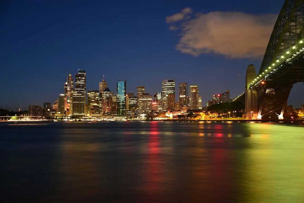 Sydney city skyline lit up at night across the harbour, Harbour Bridge on the right