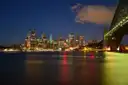 Sydney city skyline lit up at night across the harbour, Harbour Bridge on the right