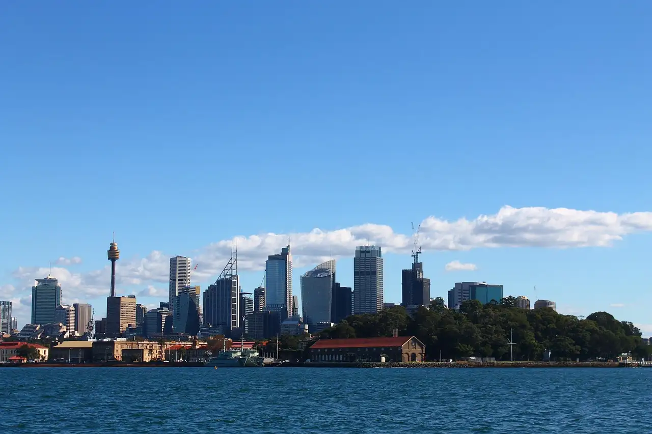 Sydney skyline across the harbour on a clear day, with Sydney Tower rising among the city towers