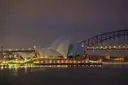 Sydney Opera House and Harbour Bridge at dusk, seen across the harbour from the Mrs Macquarie's Chair side