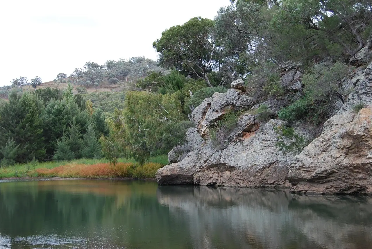 A calm river pool beside rocky bush-covered banks in New South Wales