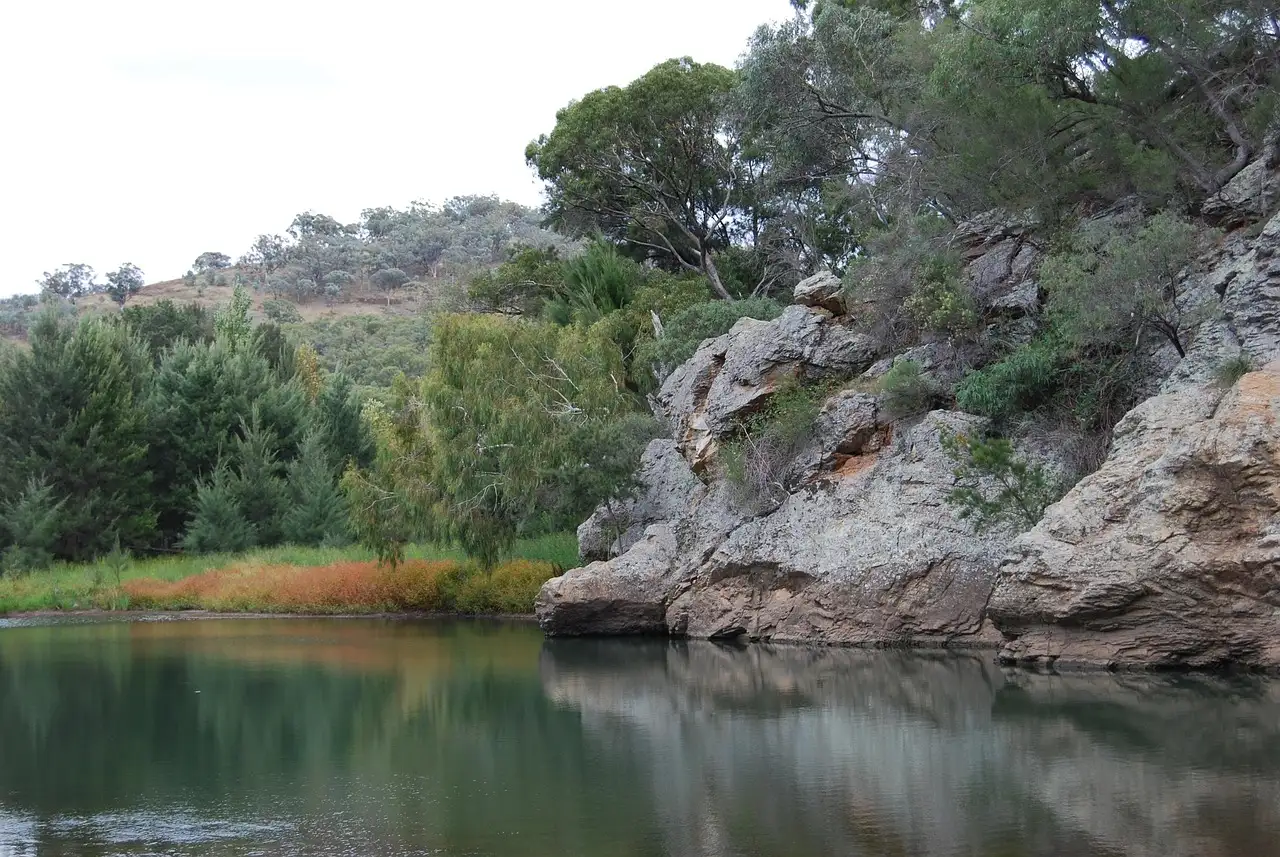 A calm river pool beside rocky bush-covered banks in New South Wales