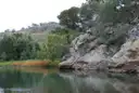A calm river pool beside rocky bush-covered banks in New South Wales