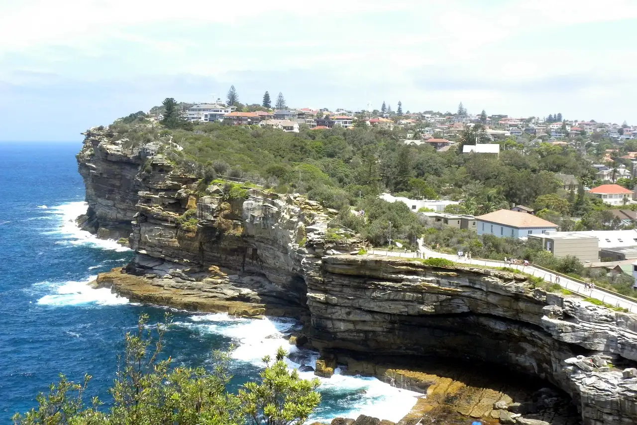 Sandstone sea cliffs at The Gap near Watsons Bay, Sydney, with waves breaking below and houses on top